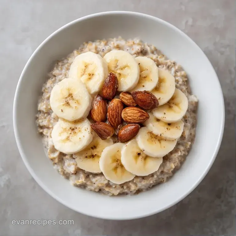 Three glass jars of creamy oatmeal arranged neatly, topped with fresh banana slices and golden toasted almonds.