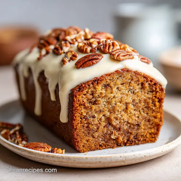 Slices of moist butter pecan cake with creamy frosting, adorned with pecan halves on a white plate, inviting presentation.