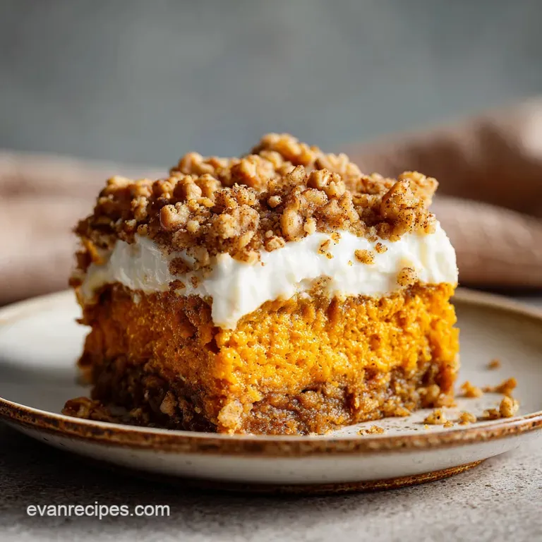 Slice of pumpkin cake showing layers of soft custard and a crunchy, caramelized top, dusted with powdered sugar on a plate.